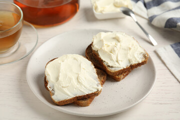 Bread with cream cheese on white wooden table