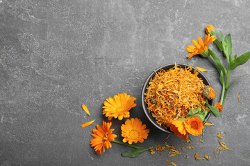 Dry and fresh calendula flowers on grey table, flat lay. Space for text - obrazy, fototapety, plakaty