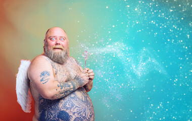 Fat amazed man with beard ,tattoos and wings acts like an magic fairy - obrazy, fototapety, plakaty