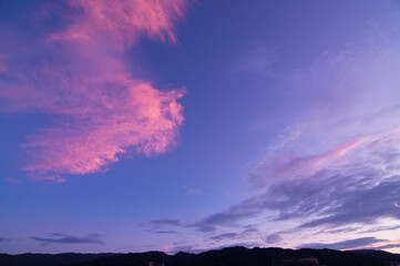 Fototapeta na wymiar 兵庫県、神戸　六甲山の夜明け。東の空から太陽が上り空と雲がオレンジ色に染まり、稜線がシルエットで浮かび上がる。