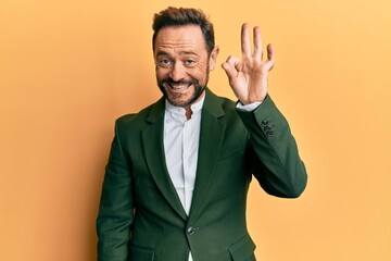 Middle age man wearing business suit smiling positive doing ok sign with hand and fingers. successful expression.