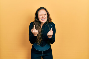 Young hispanic girl wearing diver neoprene uniform showing middle finger doing fuck you bad...