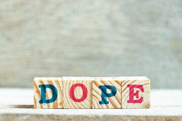 Alphabet letter block in word dope on wood background