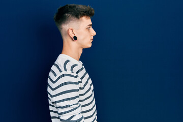 Young caucasian boy with ears dilation wearing casual striped shirt looking to side, relax profile pose with natural face with confident smile.