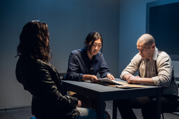 In the police station's interrogation room, good and bad cops are questioning a theft suspect in a leather jacket.