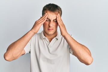 Young caucasian man wearing casual white polo with hand on head, headache because stress. suffering migraine.