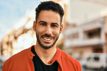 Fototapeta premium Young hispanic man smiling happy standing at the city.