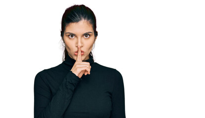 Young hispanic woman wearing casual clothes asking to be quiet with finger on lips. silence and secret concept.