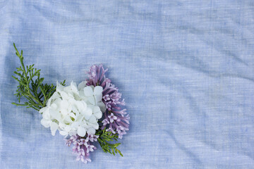 Fototapeta na wymiar A boutonniere of white hydrangea flowers lies on a linen pillow in the room.