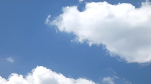 White cumulus clouds float against a blue sky