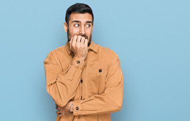 Young hispanic man wearing casual clothes looking stressed and nervous with hands on mouth biting nails. anxiety problem.