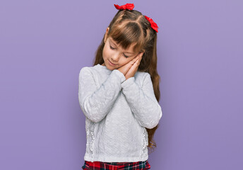Little caucasian girl kid wearing casual clothes sleeping tired dreaming and posing with hands together while smiling with closed eyes.