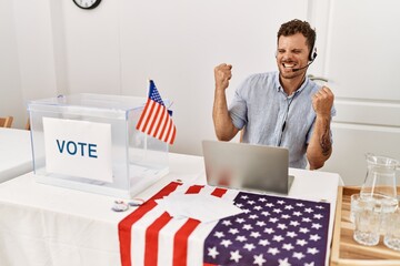 Handsome young man working at political campaign wearing operator head seat very happy and excited doing winner gesture with arms raised, smiling and screaming for success. celebration concept.