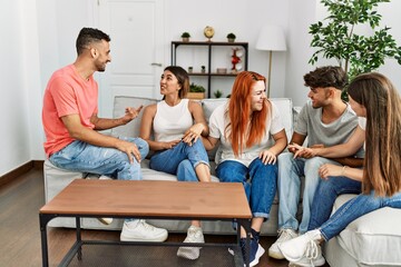 Group of young friends smiling happy sitting on the sofa at home.
