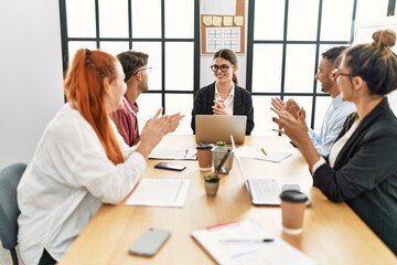 Group of business workers smiling and clapping to partner at the office.