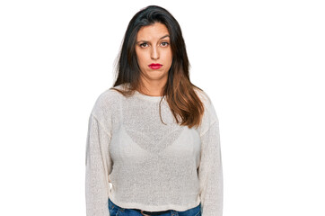 Beautiful hispanic woman wearing casual sweater skeptic and nervous, frowning upset because of...