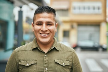 Young latin man smiling happy standing at the city.