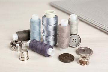 Composition with different sewing items and fabric on light beige table