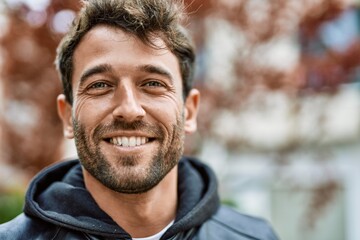 Handsome hispanic man with beard smiling happy outdoors