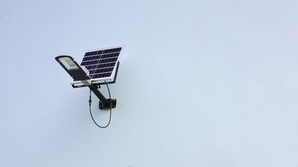 Solar cell light on the wall. A small solar panel mounted on an outdoor building wall with copy...