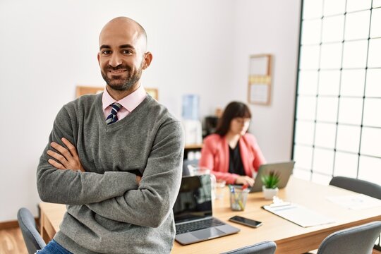 Businessman smiling happy with arms crossed gesture. Employee working at the office