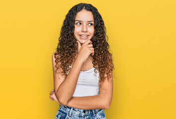 Teenager hispanic girl wearing casual clothes with hand on chin thinking about question, pensive expression. smiling with thoughtful face. doubt concept.