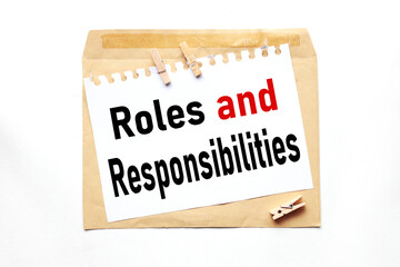 Roles and Responsibilities, text on paper on craft envelope on white background