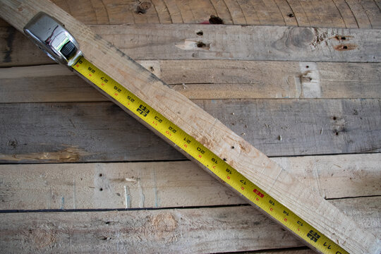 Carpenters measuring tape on wooden background