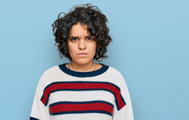 Young hispanic woman with curly hair wearing casual clothes skeptic and nervous, frowning upset because of problem. negative person.