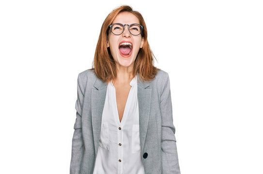 Young caucasian woman wearing business style and glasses angry and mad screaming frustrated and furious, shouting with anger. rage and aggressive concept.