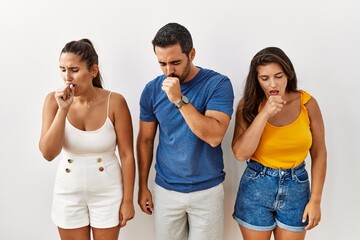 Group of young hispanic people standing over isolated background feeling unwell and coughing as symptom for cold or bronchitis. health care concept.