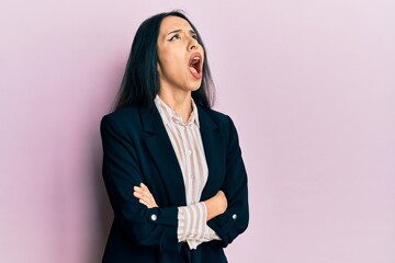 Young hispanic girl wearing business clothes with arms crossed angry and mad screaming frustrated and furious, shouting with anger looking up.