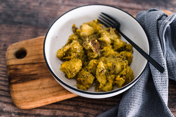 vegan oven baked smashed potatoes with pesto sauce and plant-based cheese, healthy plant-based food