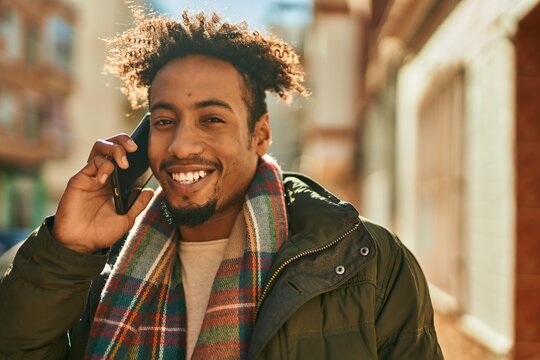 Young african american man smiling happy talking on the smartphone at the city