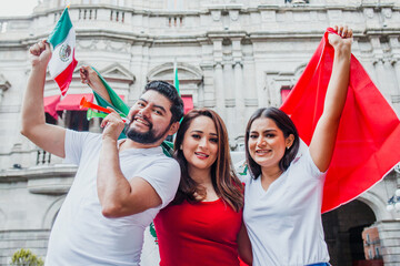 Fototapeta premium Group of mexican soccer fans holding flags and trumpets in Mexico City