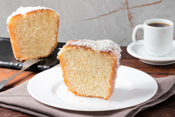 Sliced cake covered with coconut .