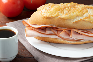 Delicious sandwich of cheese bread stuffed with turkey breast and black coffee.