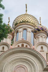 A large temple with gilded domes in trees.