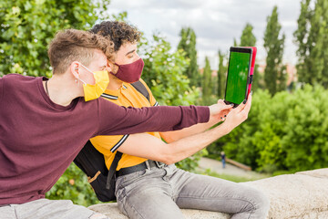 Latin young man use digital tablet. Social distance in new normal pandemic. Chroma key touchscreen