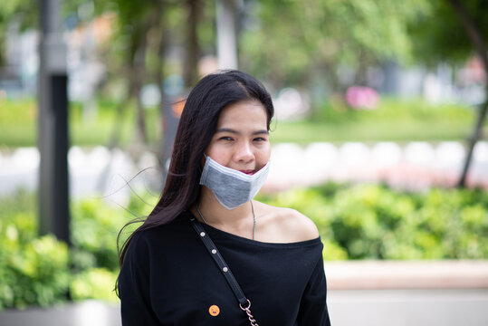 Asian Woman Don't Wear A Face Mask With Incorrect For Protection Virus Or Pollution On Outdoor Background.