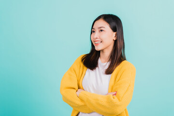 Fototapeta premium Young Asian beautiful woman smiling wear silicone orthodontic retainers on teeth with crossed arms, studio isolated on blue background, retaining tools after removable braces. Dental hygiene concept