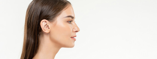 Side view beauty shot portrait of young Caucasian woman on isolated white studio banner background...