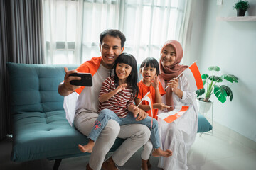 indonesian muslim asian family making selfie and video call using their phone at home