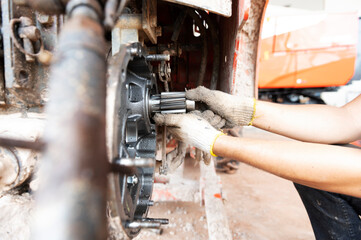 Mechanic repairing agricultural tractors, old tractors.