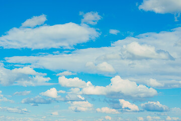 White fluffy thick clouds against the blue sky. Natural background wallpaper. The concept of clean air and ecology