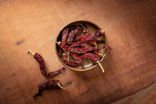 red chillis or chilli or laal mirch or mirchi in a wooden bowl on wooden dark theme