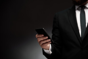 Close up of man in suit using smart phone