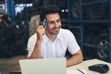 Businessman using credit card and laptop computer working while in warehouse factory, entrepreneurship or business owner and internet of thing concept