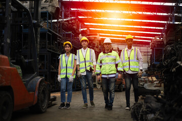 Worker or Engineer team smart posing while walking  in machine spare part engine warehouse or factory