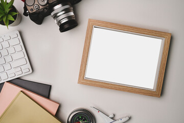 Empty photo frame, camera and notebook on photographer workspace.